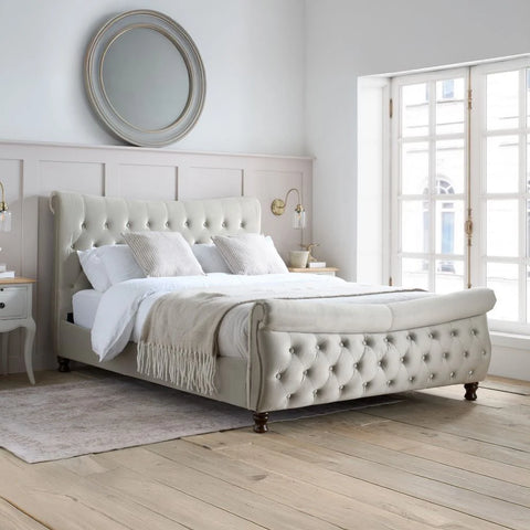 Osborne warmstone velvet chesterfield ottoman bed in a bright bedroom setting with large windows