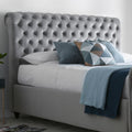 Close up of grey velvet tufted headboard on the Osborne chesterfield ottoman bed with decorative pillows