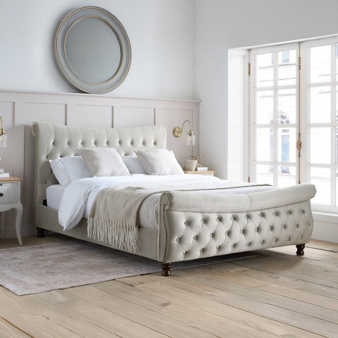 Osborne warmstone velvet chesterfield ottoman bed in a bright bedroom setting with large windows