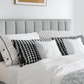 Rhodes grey velvet ottoman bed with contemporary headboard and checkered pillows in a bedroom setting