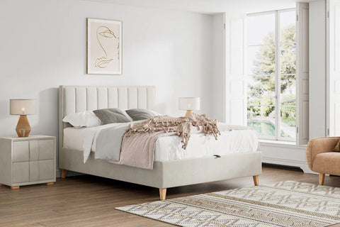 Rhodes warmstone velvet ottoman bed styled with grey bedding in a bright bedroom with large windows