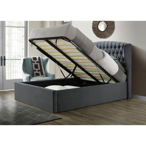 Warwick grey velvet wingback ottoman bed with mattress base lifted open showing under-bed storage in a styled bedroom