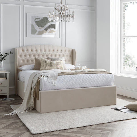 Warwick velvet ottoman bed in natural cream styled in a modern bedroom setting with winged headboard