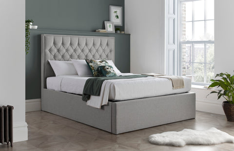 Wilson grey fabric ottoman bed with buttoned headboard in a modern bedroom setting